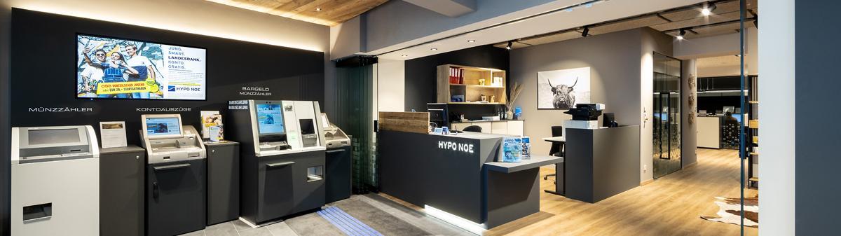 Eingangsbereich der Filiale mit Bankgeräten und Schalter