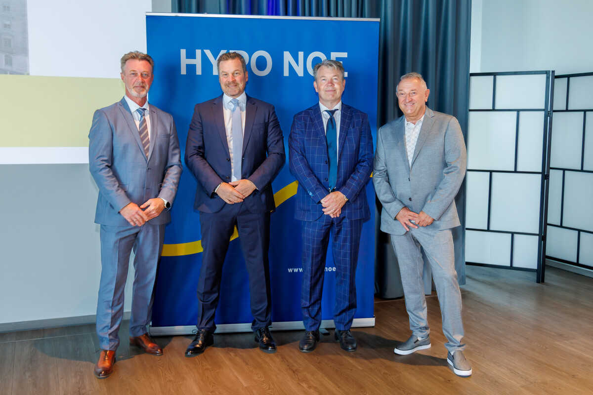 Vier Männer in Anzug und Krawatte stehen vor einem blauen HYPO NOE Banner.
