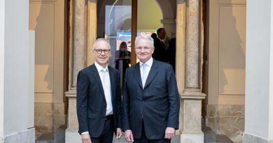 Zwei Männer in Anzug und Krawatte.