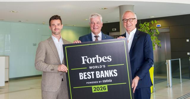 drei Männer in Anzug und Krawatte halten ein Schild mit der Aufschrift "Forbes World's Best Banks"