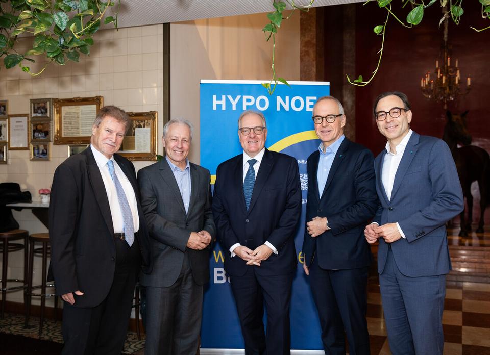 Fünf Männer in Anzug und Krawatte stehen vor einem blauen HYPO NOE Rollup.