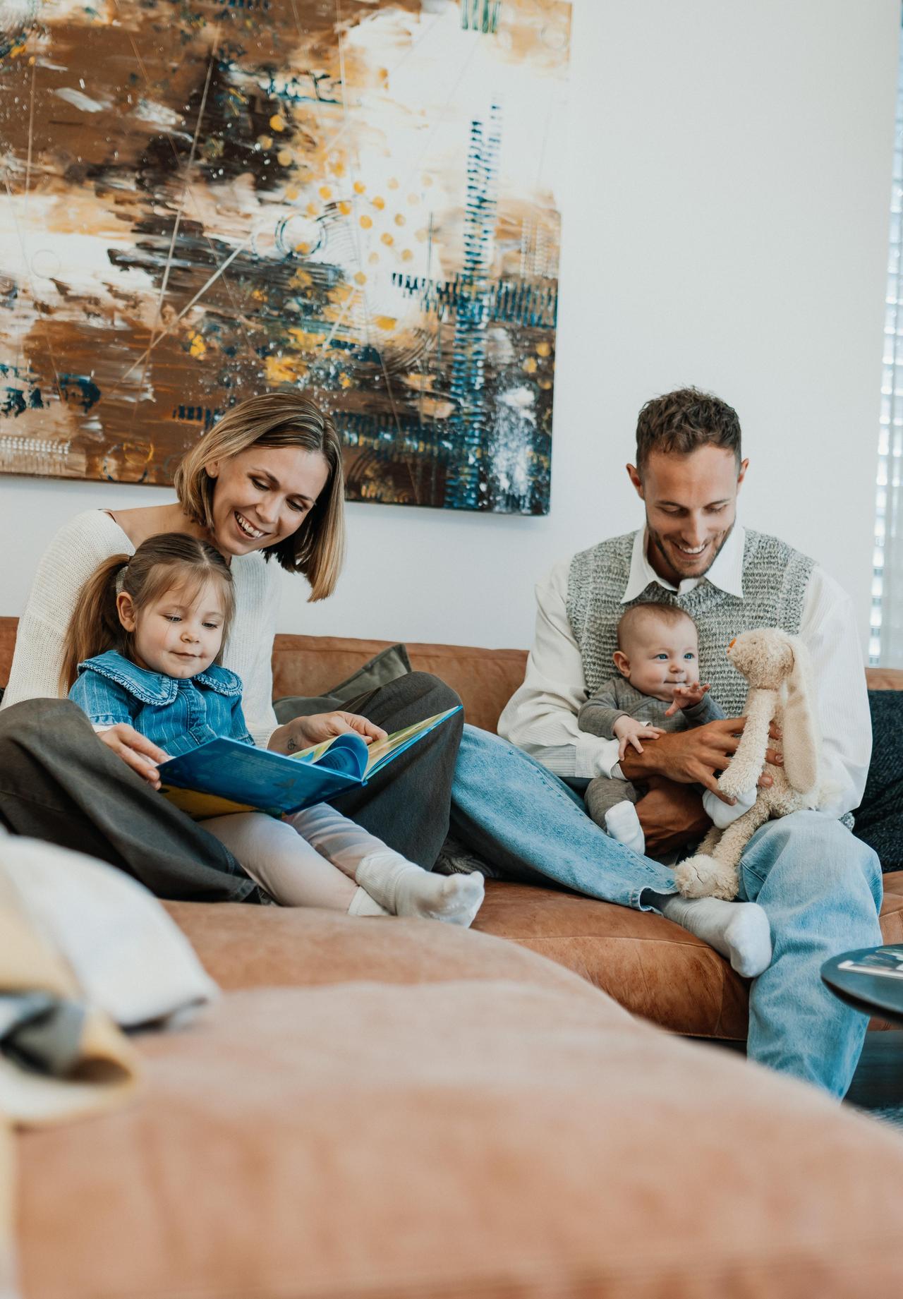 Mutter und Kind lesen Kinderbuch auf Couch