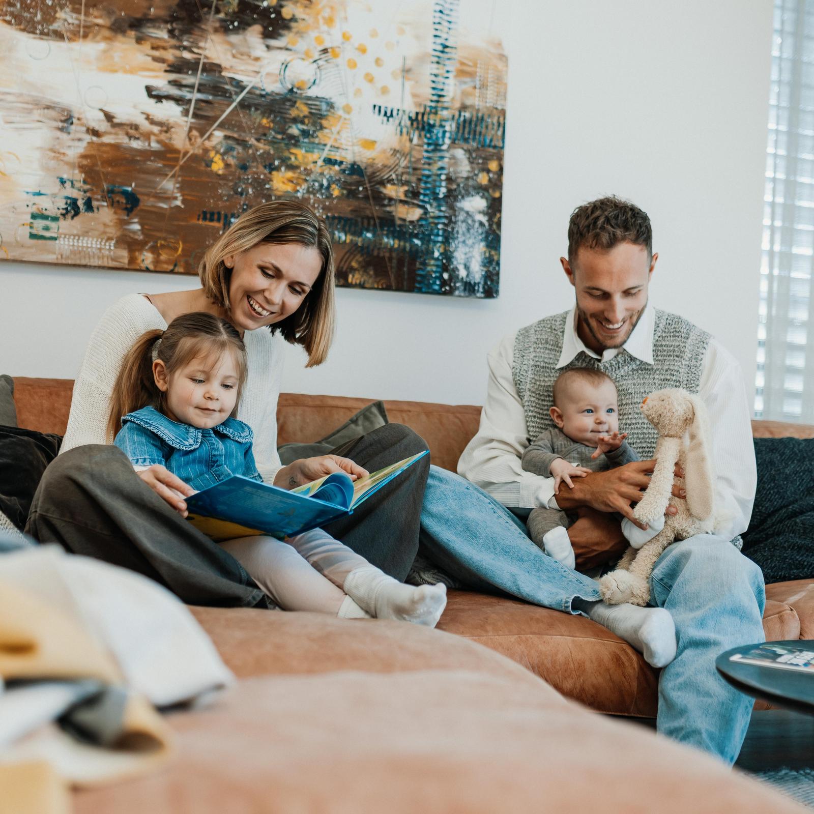 Mutter und Kind lesen Kinderbuch auf Couch