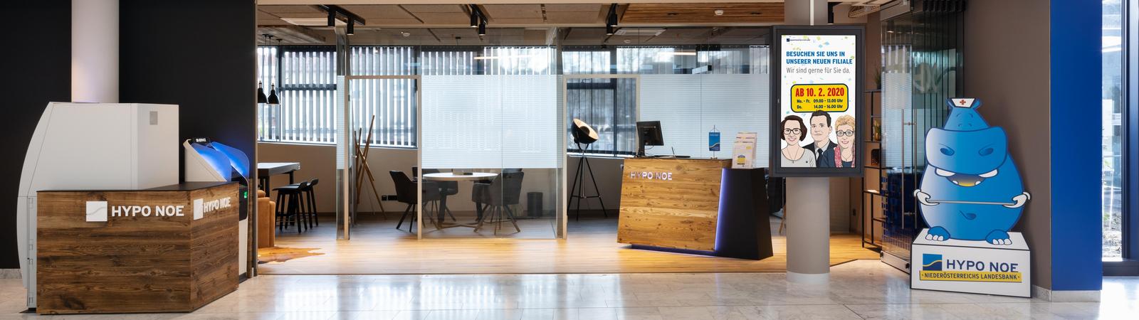 Blick auf die Filiale mit Beratungsräumen, links sind Bankgeräte zu sehen