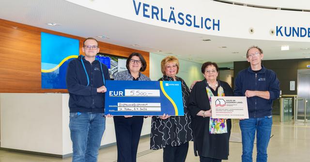 Zwei Männer und drei Frauen halten zwei Schilder: Einen Spendenscheck in blau mit 5.500 Euro und ein Schild mit Vereinslogo von Hilfe im eigenen Land.
