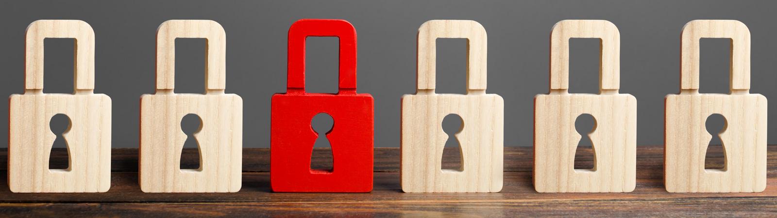 Rotes Vorhängeschloss unter weiteren Vorhängeschlössern