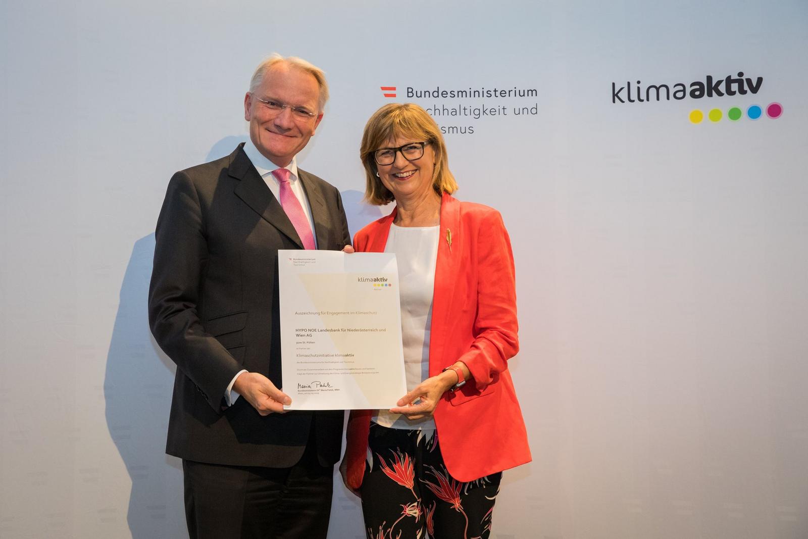 Ein Mann und eine Frau halten eine Urkunde für die HYPO NOE Landesbank.