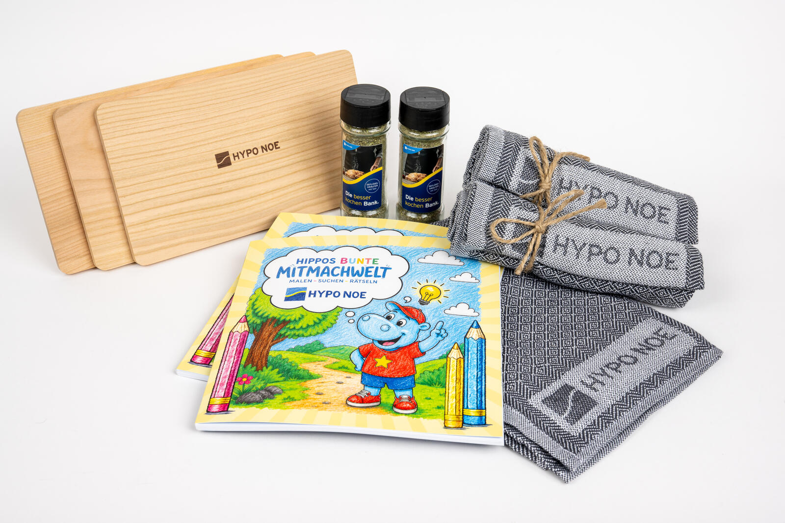 Weltspargeschenke: Schneidbretter, Gewürze, Geschirrtücher und Kinderhefte mit HYPO NOE Logo.
