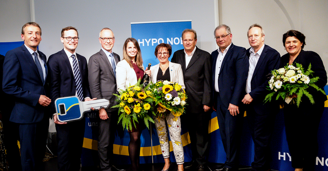 Eine Gruppe von Menschen in Business Kleidung in einem Raum bei der Schlüsselübergabe in der HYPO NOE Filiale Horn