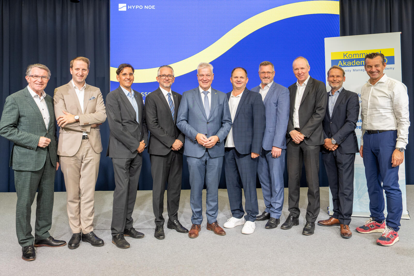 Gruppenfoto von zehn Personen auf einer Bühne vor HYPO NOE- und Kommunalakademie-Banner.