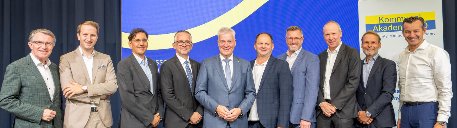 Gruppenfoto von zehn Personen auf einer Bühne vor HYPO NOE- und Kommunalakademie-Banner.