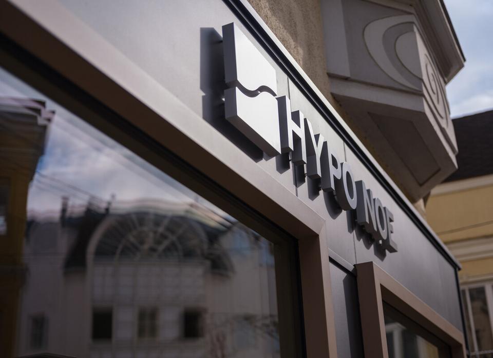 Schriftzug "HYPO NOE" mit Logo-Würfel an der anthrazitfarbenen Außenfassade, darunter ein Fenster.