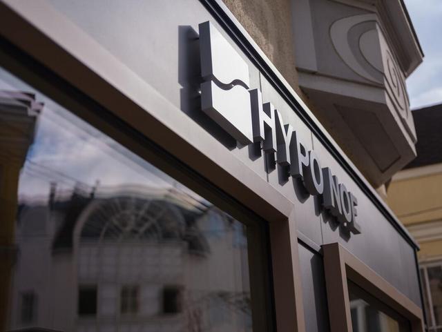 Schriftzug "HYPO NOE" mit Logo-Würfel an der anthrazitfarbenen Außenfassade, darunter ein Fenster.