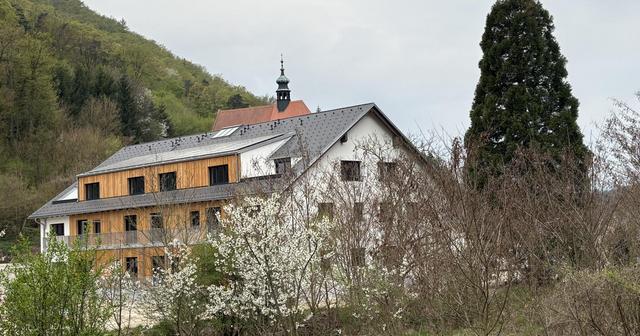 Ein mehrstöckiges Gebäude mit Bäumen im Vordergrund.