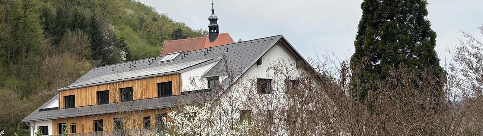 Ein mehrstöckiges Gebäude mit Bäumen im Vordergrund.