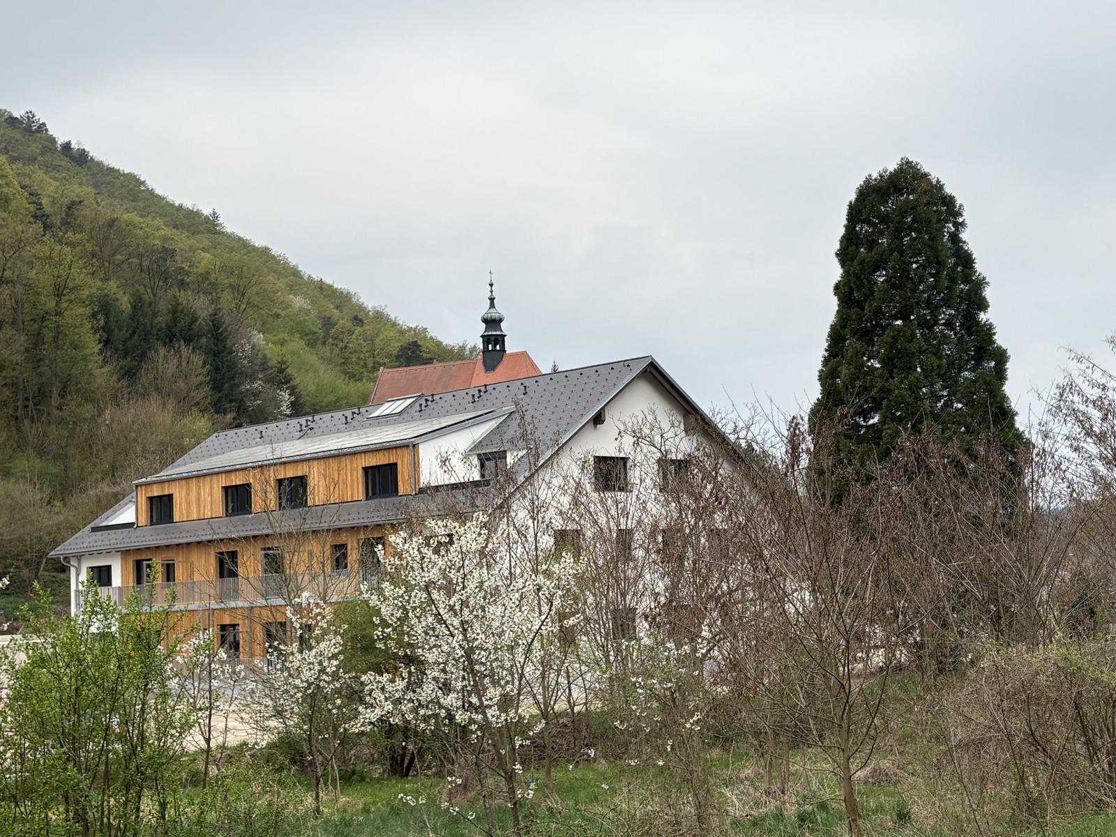 Ein mehrstöckiges Gebäude mit Bäumen im Vordergrund.