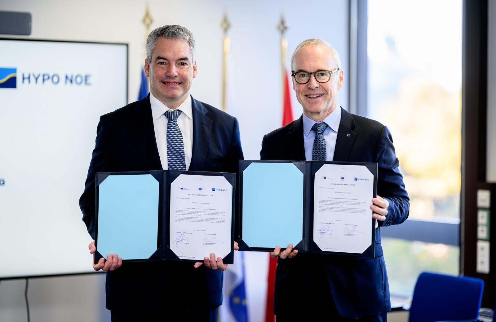 Zwei Männer in Anzug und Krawatte halten Mappen mit unterzeichneten Dokumenten.