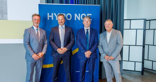 Vier Männer in Anzug und Krawatte stehen vor einem blauen HYPO NOE Banner.