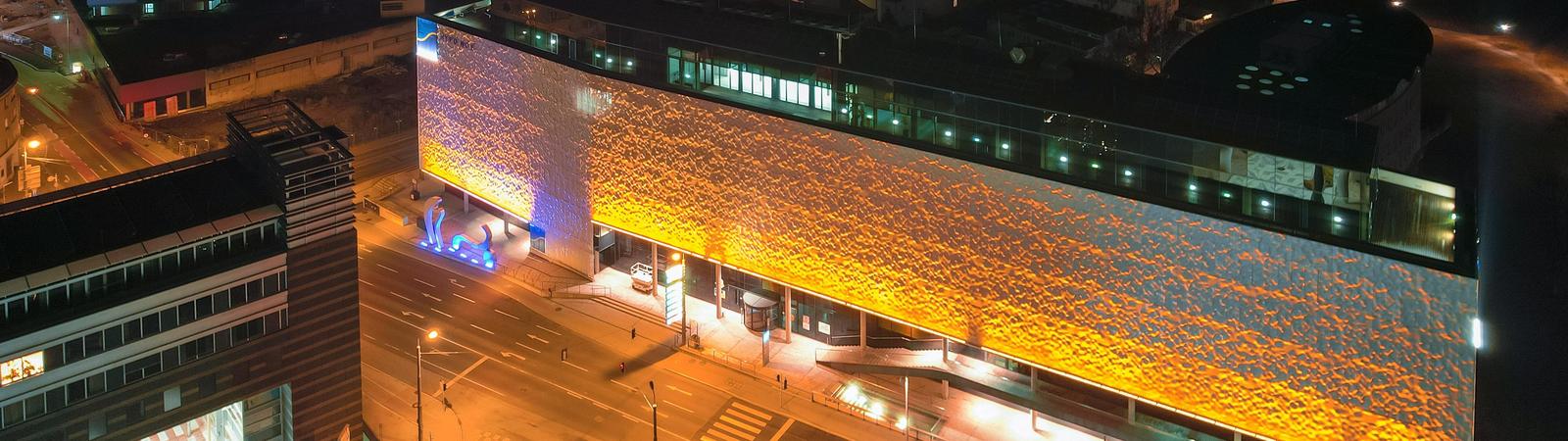 Blick von oben auf die orange erleuchtete HYPO NOE Zentrale in St. Pölten