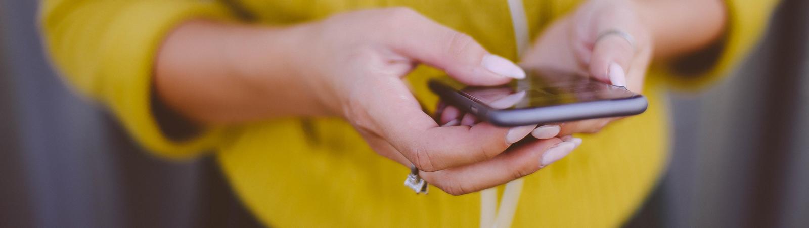Junge Frau nutzt das HYPO NOE 24/7 Internetbanking am Smatphone