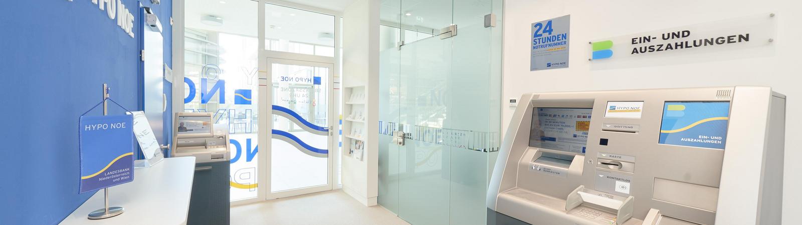 Raum mit Kontoauszugsdrucker und Bankomat, geradeaus sind zwei Türen zu sehen.