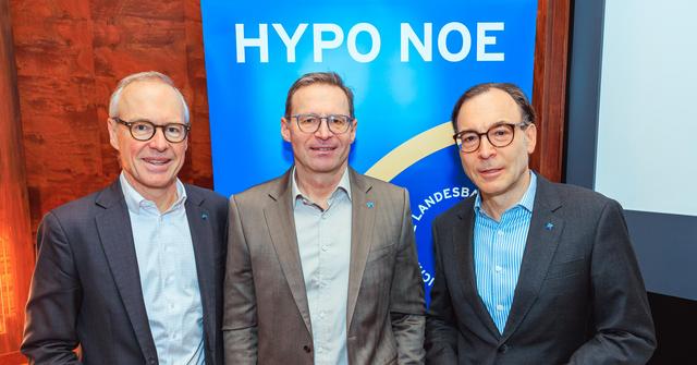 Drei Männer mittleren Alters in Anzügen stehen vor einem blauen Banner mit der Aufschrift "HYPO NOE".