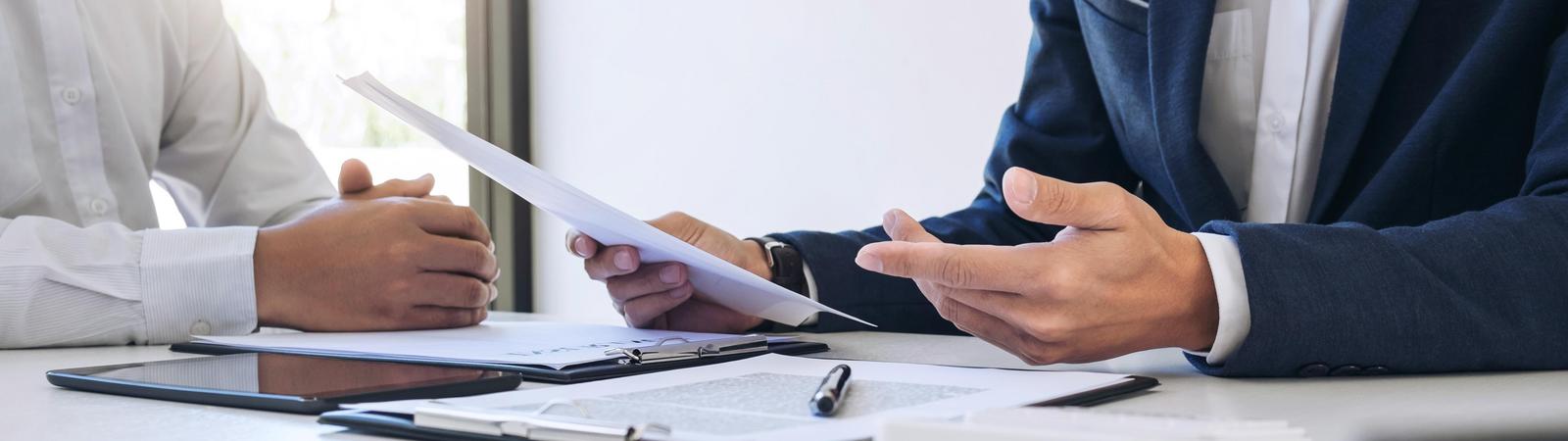 Ein Versicherungsberater erklärt einem Kunden eine Versicherungspolizze