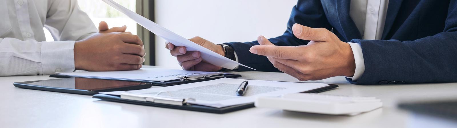 Ein Versicherungsberater erklärt einem Kunden eine Versicherungspolizze