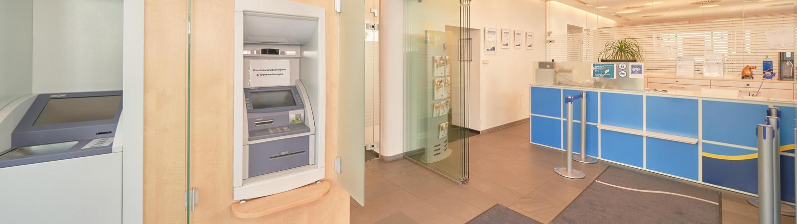 Foyer einer Bankfiliale mit Bankomat, Kontoauszugsdrucker und rechts Schalter.