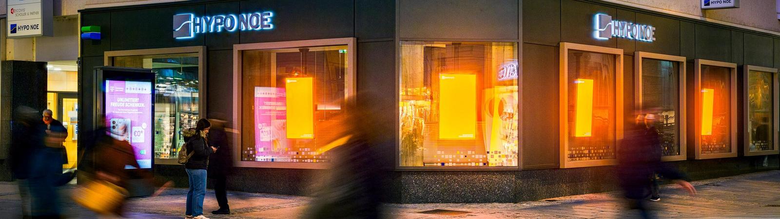 ein Gebäude im dunklen mit orange leuchtenden Fenstern