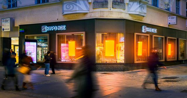 ein Gebäude im dunklen mit orange leuchtenden Fenstern